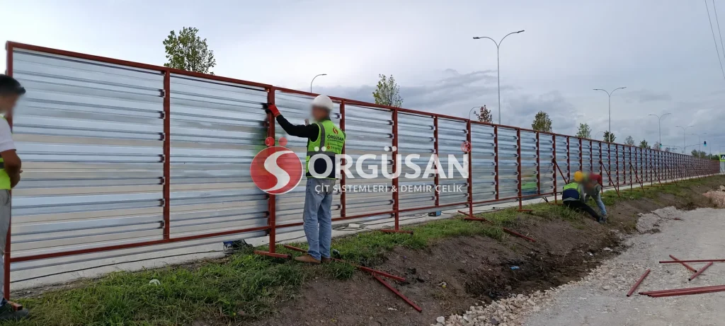 Sakarya projesinde kırmızı profilli trapez sac panoları yerleştiren ÖRGÜSAN montaj ekibi